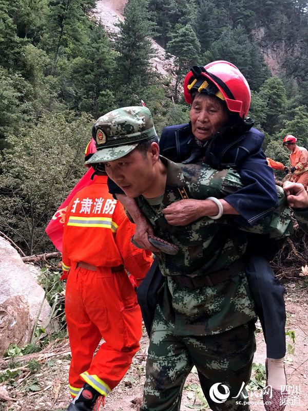 武警水电三总队突击队队员在返程途中，将受伤旅客背出最危险的塌方路段。（ 蔡必维  摄）